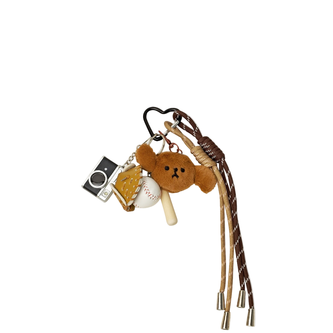 Keychain charm with puppy dog plush, camera charm, and baseball charm on a white background