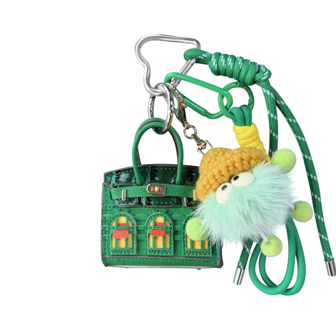 Green leather structured mini bag charm shaped like a house, featuring decorative window panels and a top handle.