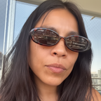 Person wearing sunglasses with a cityscape background