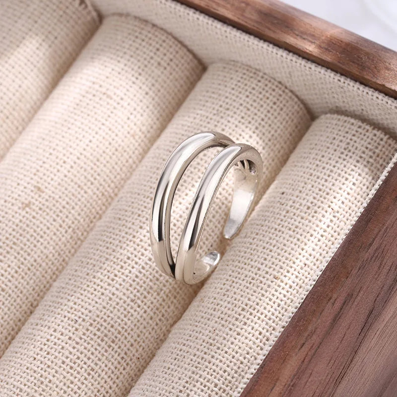 Silver ring on beige fabric with wooden base