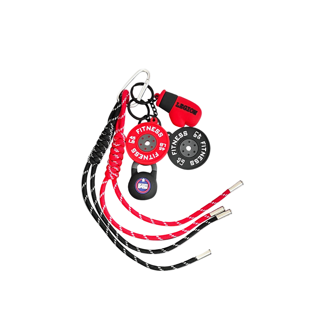 Keychain charm featuring miniature weight plates, black kettlebell, and red boxing glove components, linked with red and black patterned cords.