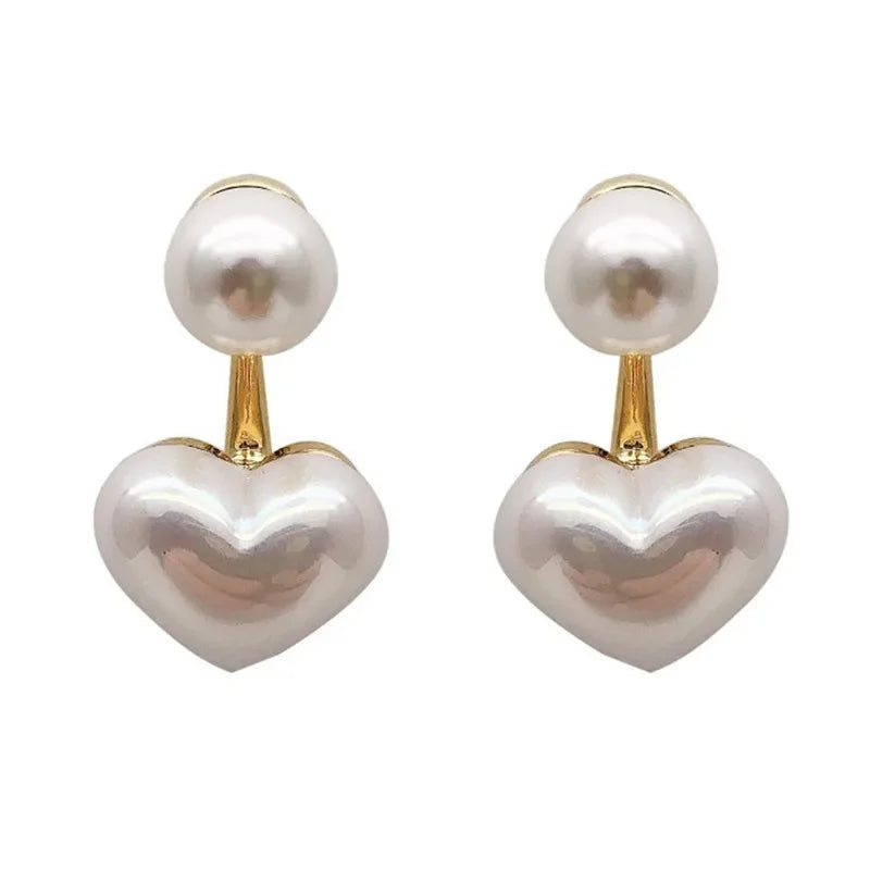 Heart-shaped pearl earrings with gold accents on a white background