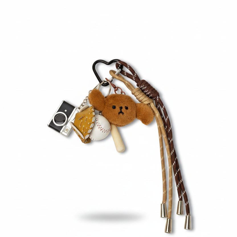 Keychain charm with puppy dog plush, camera charm, and baseball charm on a white background