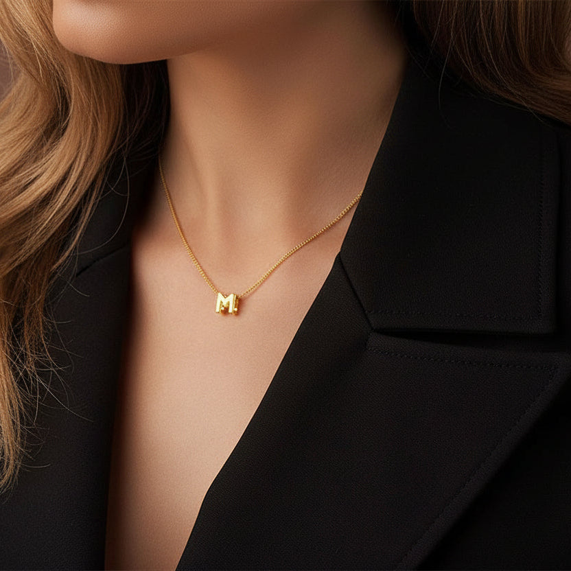 Close-up of a woman wearing a gold necklace with a small pendant.