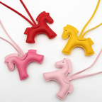 Four horse-shaped necklaces in red, pink, and yellow on a white background