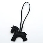Black horse-shaped keychain with a strap on a white background