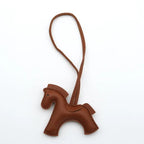 Brown leather horse-shaped keychain on a white background