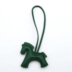 Green horse-shaped keychain on a white background