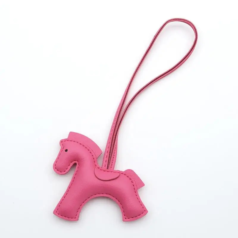 Pink horse-shaped keychain with a strap on a white background
