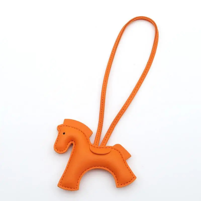 Orange horse-shaped keychain on a white background