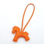 Orange horse-shaped keychain on a white background