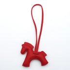 Red horse-shaped keychain with a strap on a white background