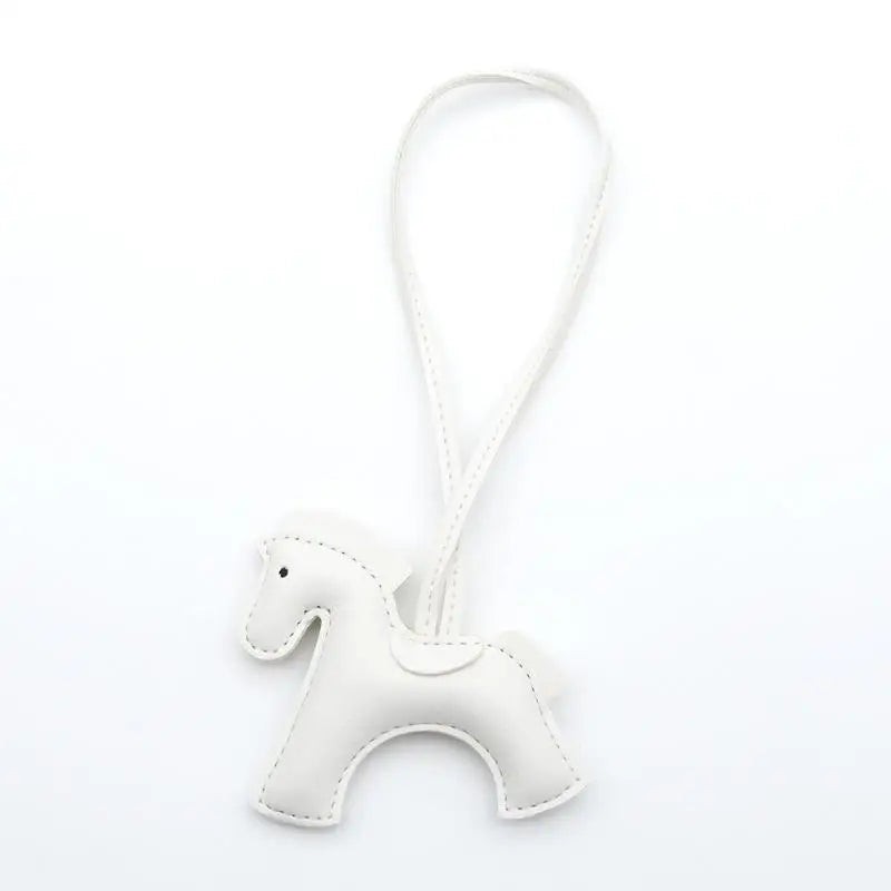 White horse-shaped keychain on a white background