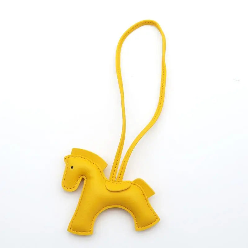 Yellow horse-shaped keychain on a white background