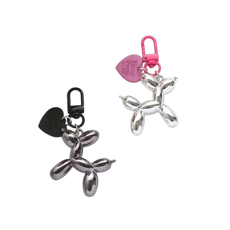 Metallic balloon dog keychains with pink and black carabiners on a white background