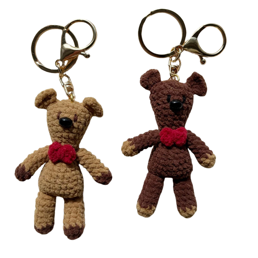 Two teddy bear keychains with red hearts on a white background
