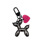 Keychain shaped like a balloon dog with a pink heart tag on a white background