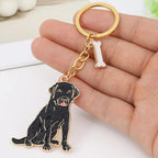 Keychain with a black lab dog design held in a hand on a white surface