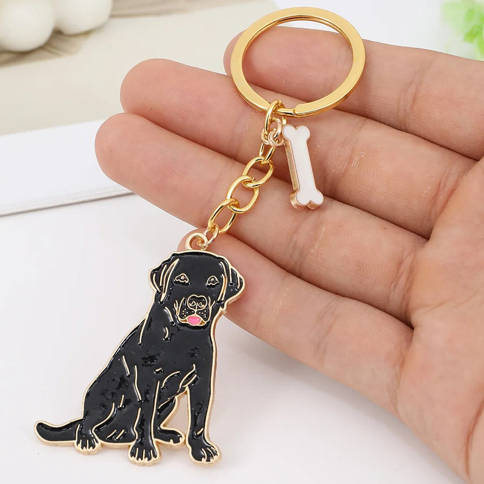 Keychain with a black lab dog design held in a hand on a white surface