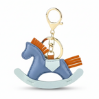 Blue rocking horse keychain with gold and brown accents on a white background