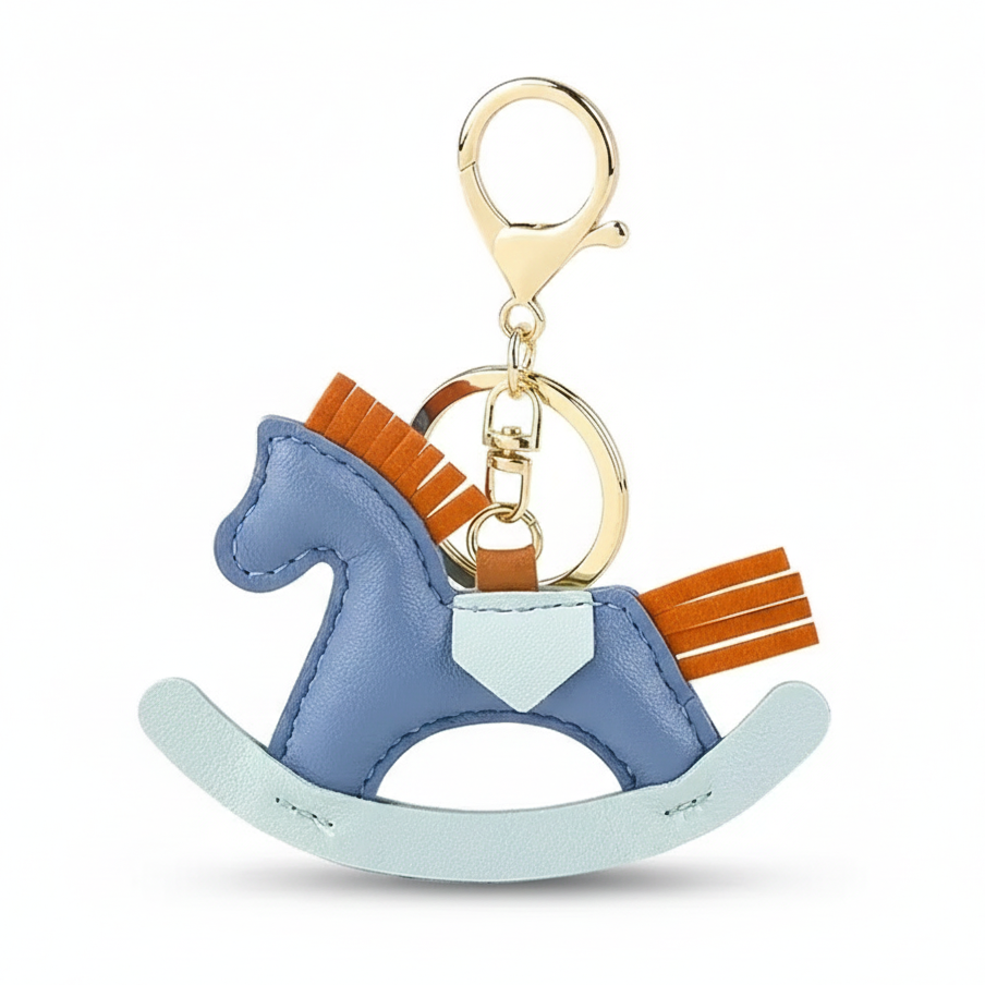 Blue rocking horse keychain with gold and brown accents on a white background