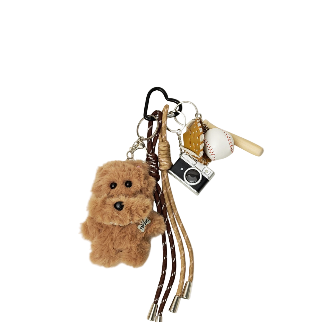 Brown fuzzy plush teddy bear bag charm with baseball, baseball bat, glove, and silver camera components hanging from a keychain.