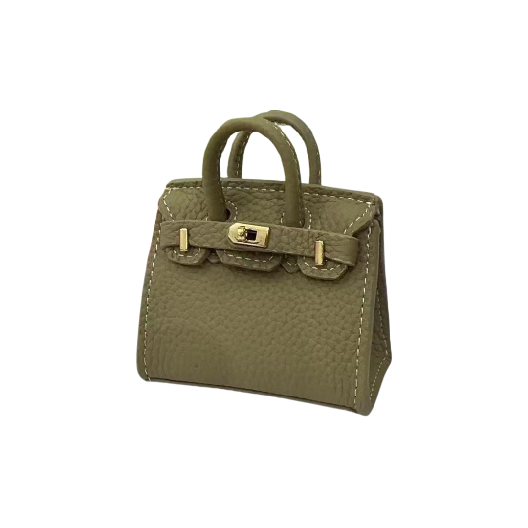 Khaki genuine leather structured bag charm with top handle, flap closure, securing straps, and gold-tone padlock hardware.