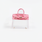 Pink top handle and base, clear panel structured mini bag charm with gold-tone hardware.