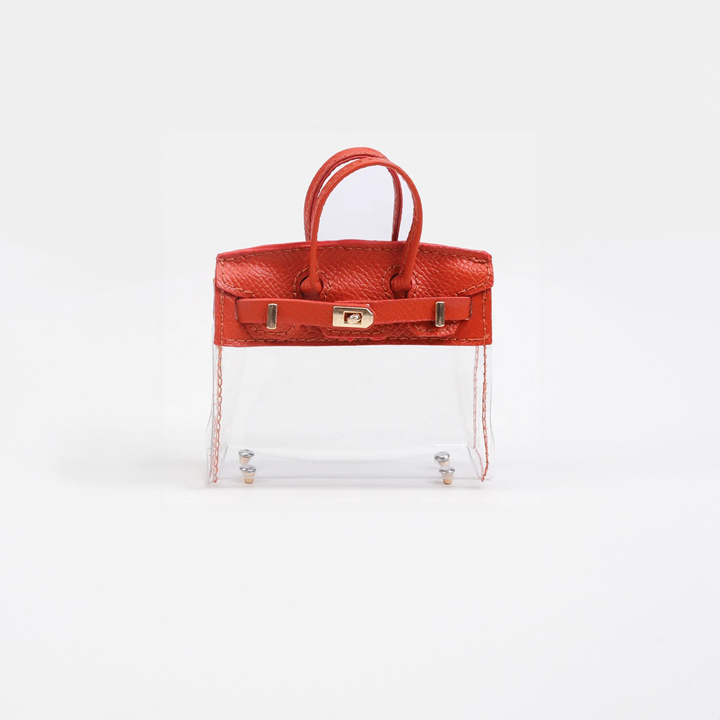 Red top handle and base, clear panel structured mini bag charm with gold-tone hardware.
