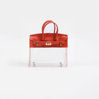 Red top handle and base, clear panel structured mini bag charm with gold-tone hardware.