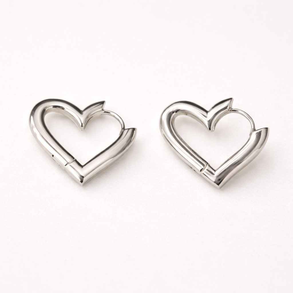 Pair of silver heart-shaped hoop earrings on a white background
