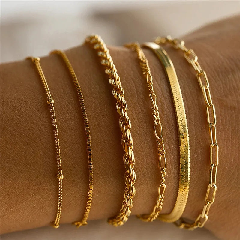 Gold bracelets on a wrist with a blurred background