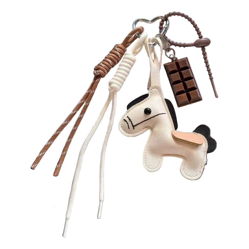 Unicorn-shaped keychain with heart-shaped lanyard on a dark surface