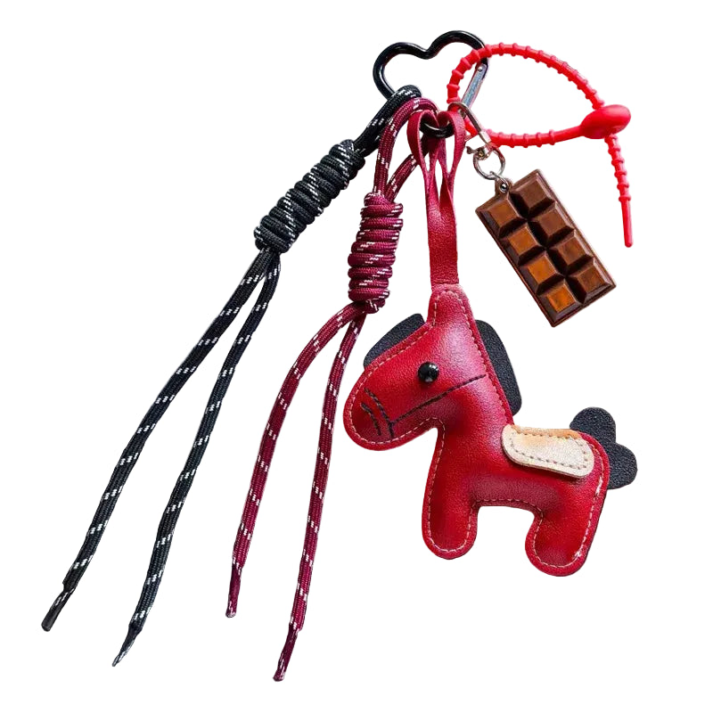 Red horse-shaped keychain with braided straps on a dark surface