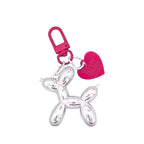Keychain shaped like a silver balloon dog with a pink heart and clip on a light gray background