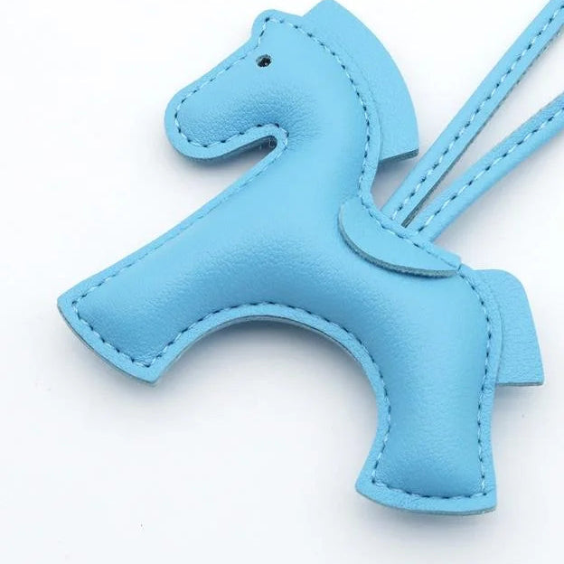 Blue horse-shaped keychain on a white background