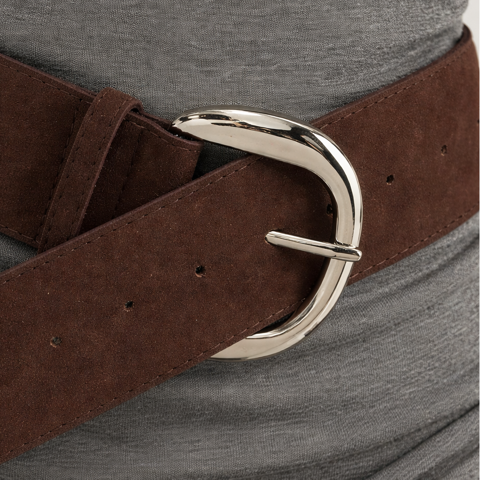 Brown belt with a silver buckle worn by a person on a gray background
