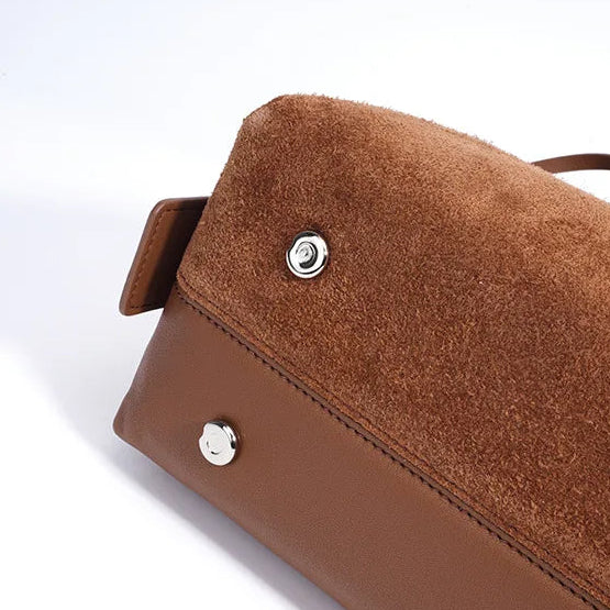 Brown handbag with visible stitching and hardware on a white background