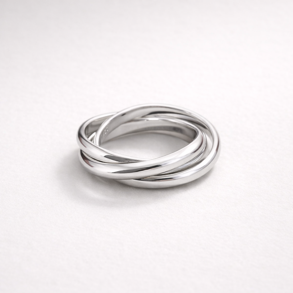 Silver ring with three intertwined bands on a white background