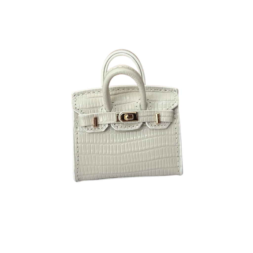 White genuine leather structured charm with a fine pebbled/grained texture and top handle.