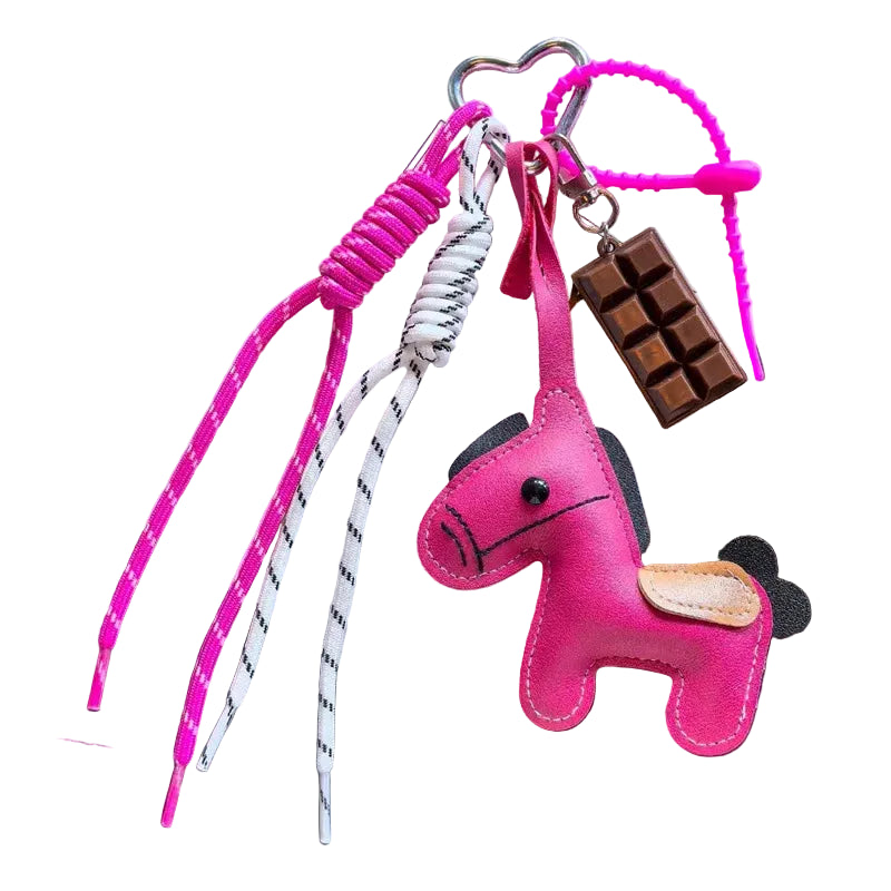 Pink keychain with a horse design on a dark surface