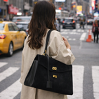 Person with a black handbag crossing a city street