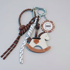 Keychain with horse design and decorative elements on a light gray background