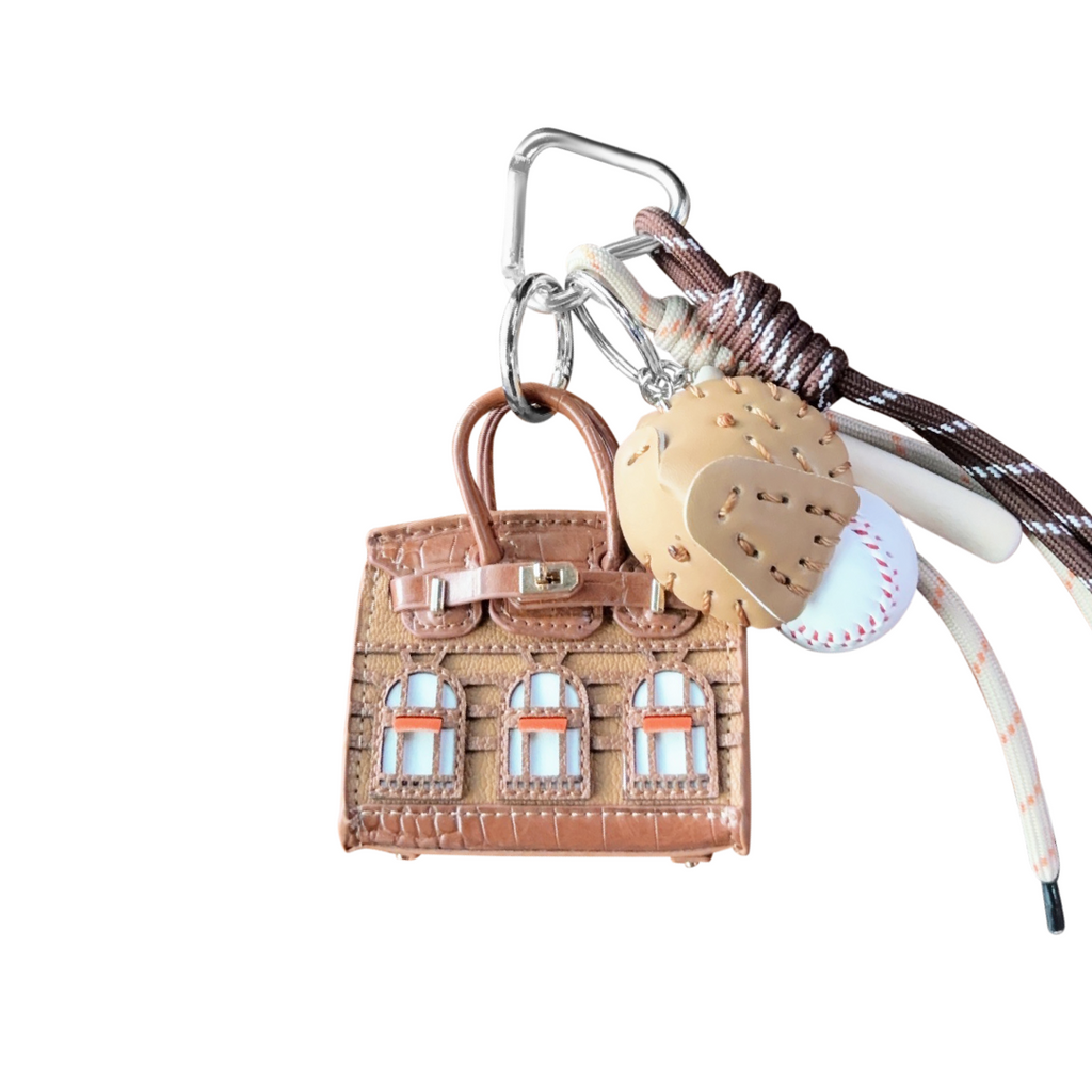 Light Brown leather structured mini bag charm shaped like a house, featuring decorative window panels and a top handle.