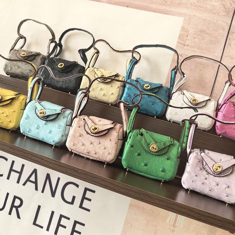 Row of colorful mini-bag charms on a shelf with motivational text in the background.