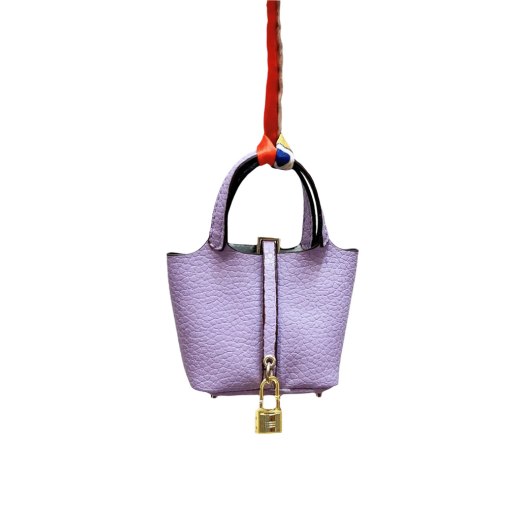 Lavender leather mini bucket bag charm with gold padlock detail, structured sides, and open-top storage functionality.