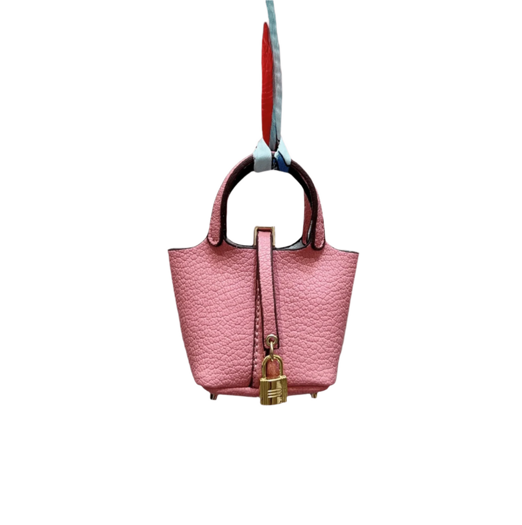 Pink leather mini bucket bag charm with gold padlock detail, structured sides, and open-top storage functionality.