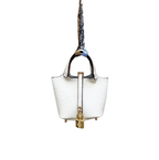 A white leaWhite leather mini bucket bag charm with gold padlock detail, structured sides, and open-top storage functionality.ther picnic tote bag charm with a metallic clasp and a brown leather handle.