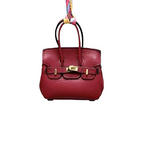 Burgundy genuine leather Mini Purse Iconic Bag Charm with structured shape, top handle, securing straps, and gold-tone padlock.