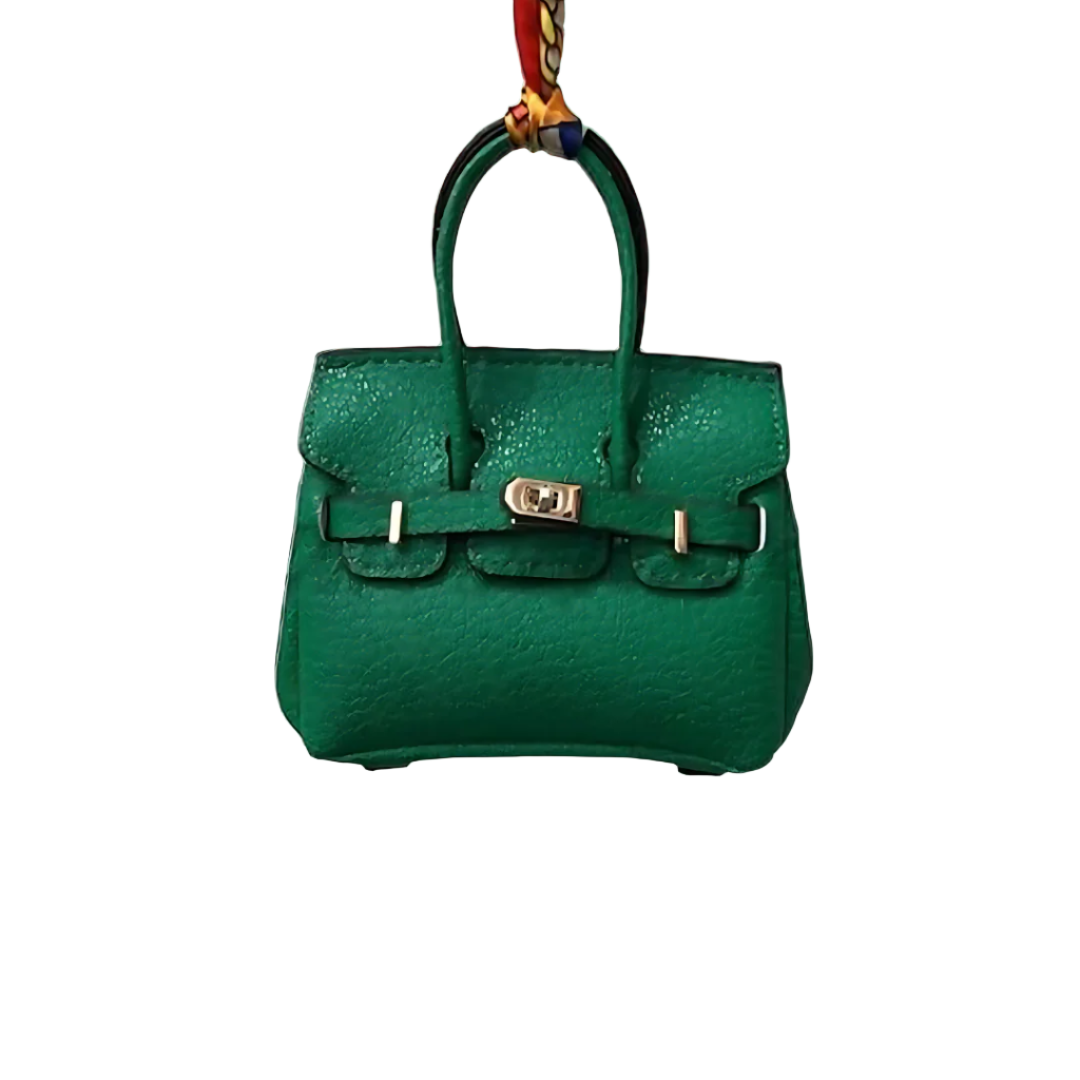 Green genuine leather Mini Purse Iconic Bag Charm with structured shape, top handle, securing straps, and gold-tone padlock.